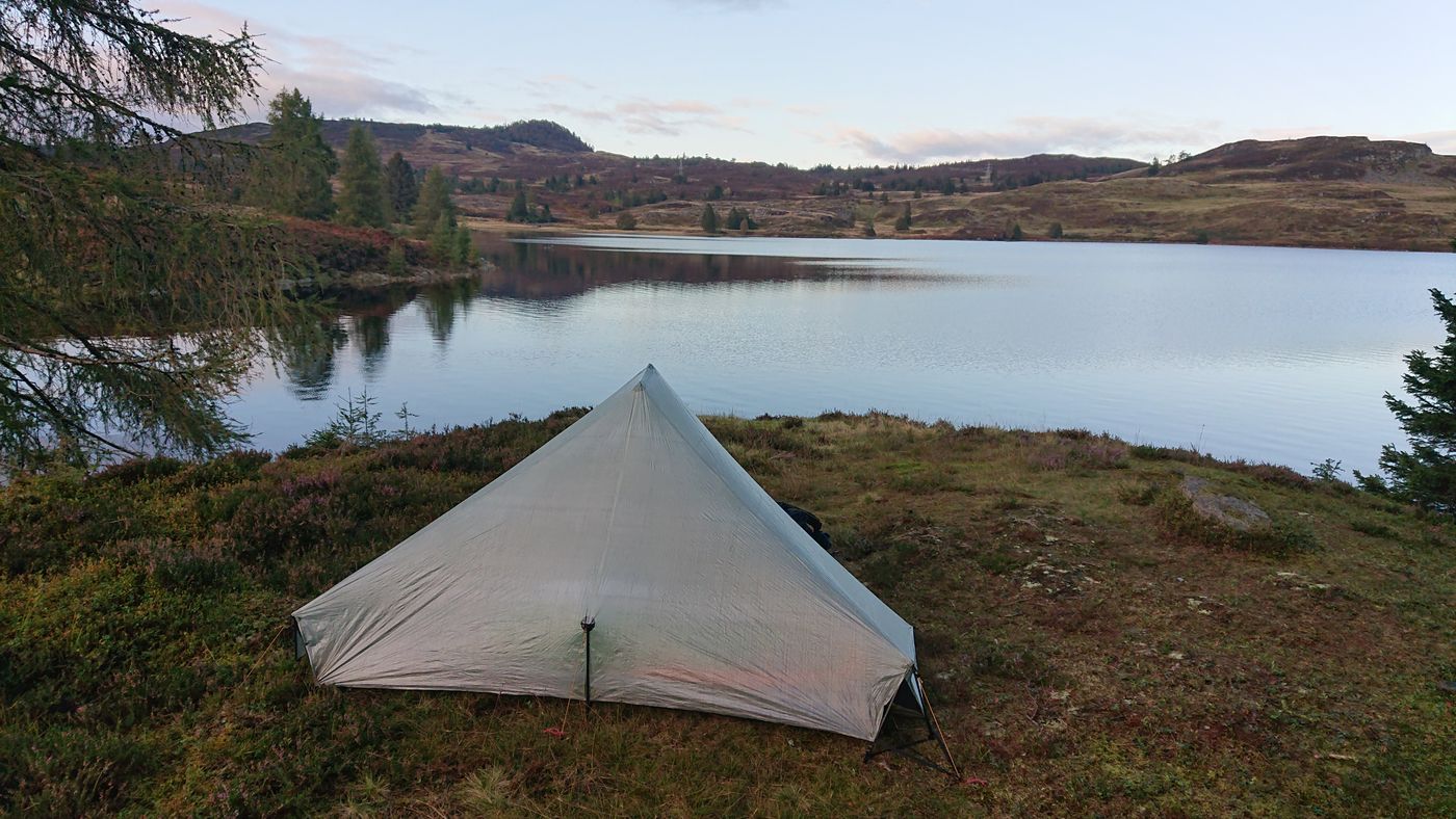 Shelter pitched beside a peaceful Highland loch at dusk